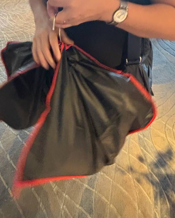A customer holding a garment bag in a hotel lobby