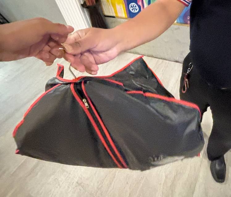 A London Bespoke Tailors garment bag being handed over for hotel service