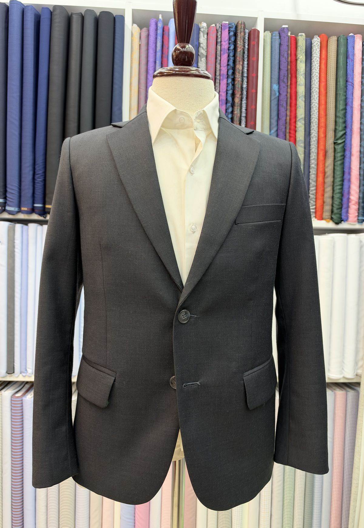 Charcoal jacket with a cream shirt on a stand