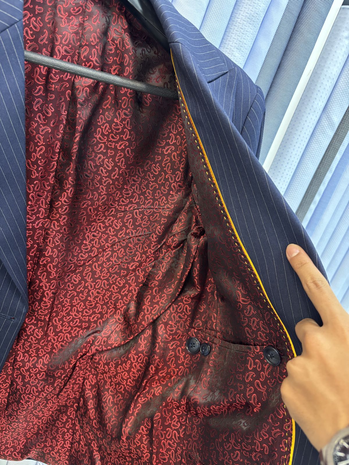 Navy pinstripe jacket held open to show a red paisley lining