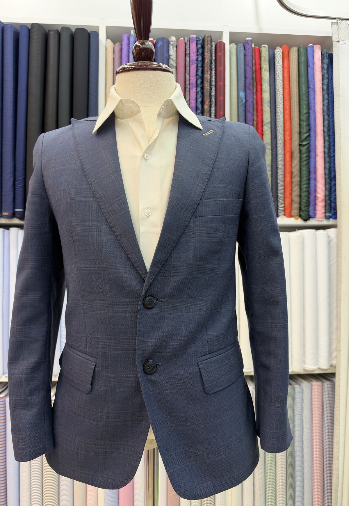 Navy check suit jacket on a stand in the shop