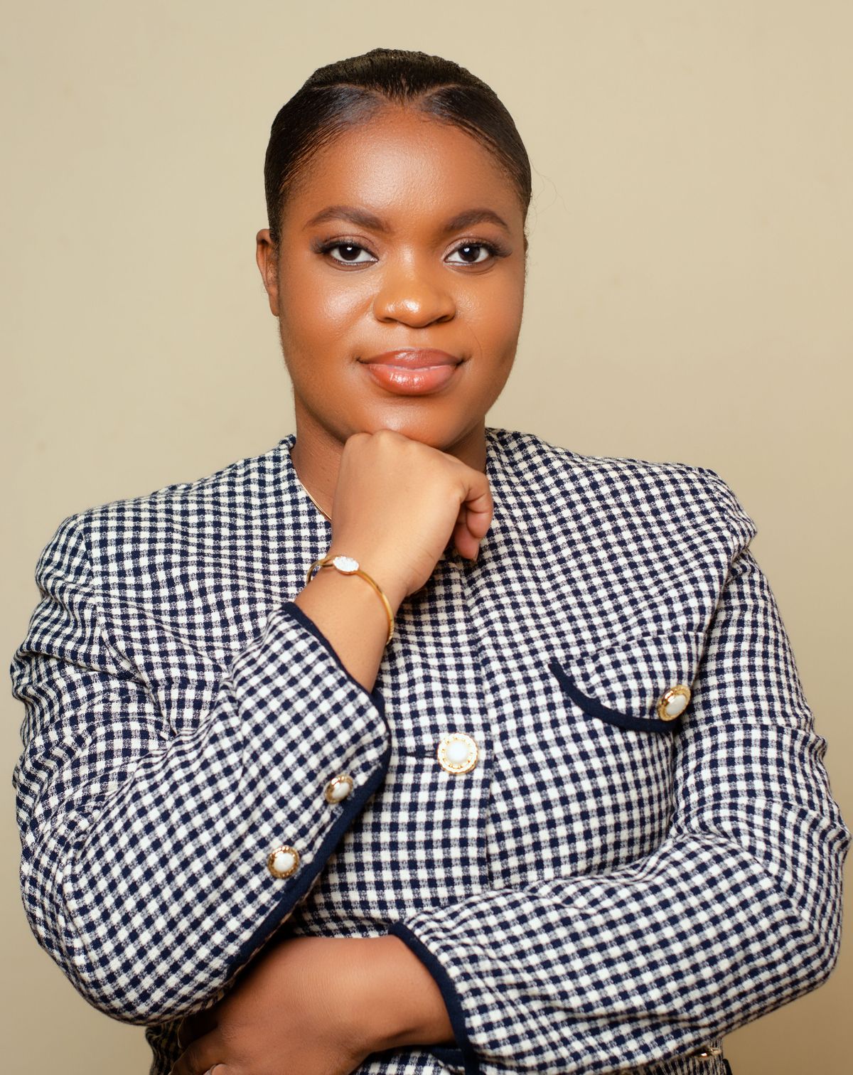 A woman in a navy and white check tailored jacket with gold buttons