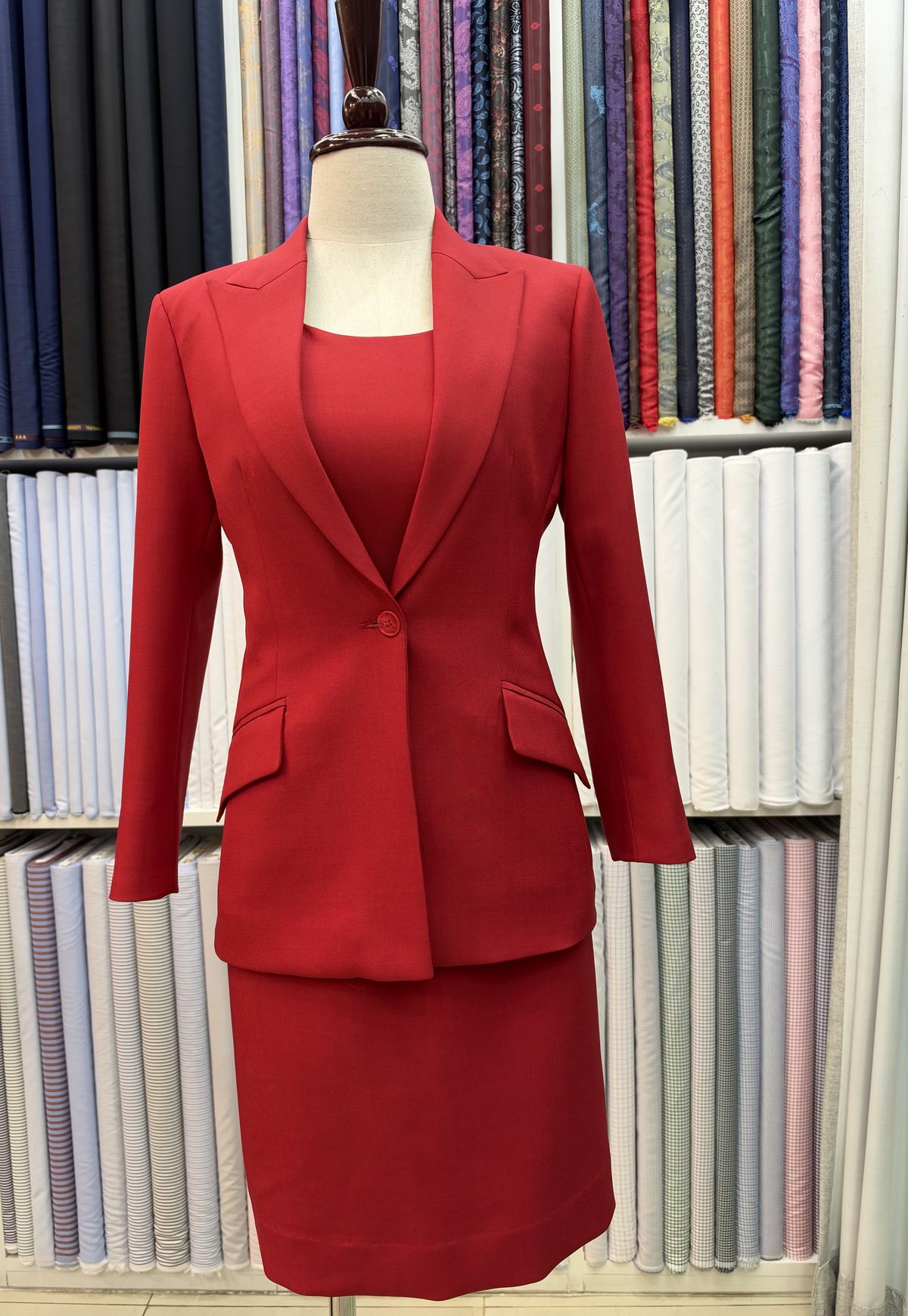 Red women’s skirt suit on a dress form in the shop